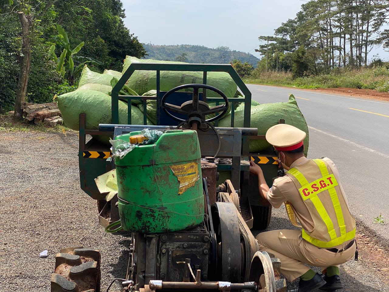 Cán bộ Trạm CSGT Krông Búk dán decal phản quang miễn phí vào phía trước thành, thùng xe cho người dân.