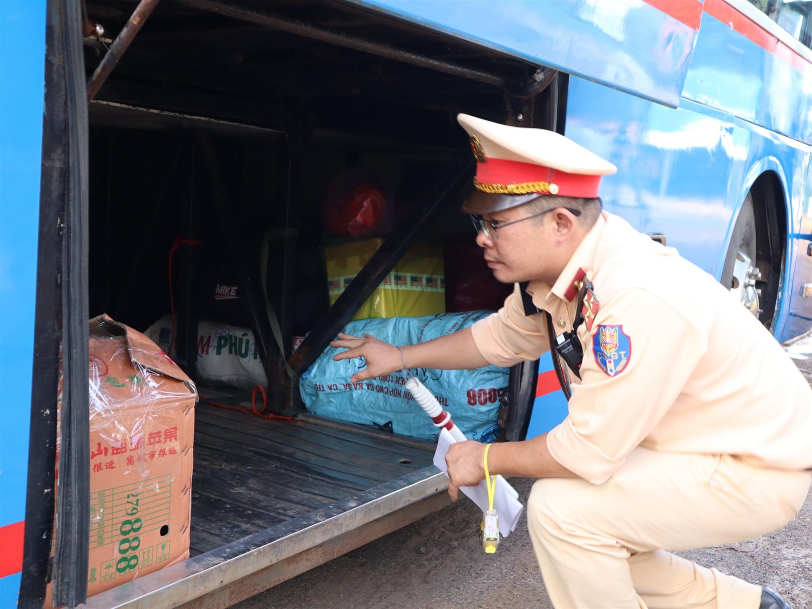 Cán bộ Phòng CSGT, Công an tỉnh kiểm tra khoang chở hàng hóa của xe khách lưu thông trên đường Hồ Chí Minh.